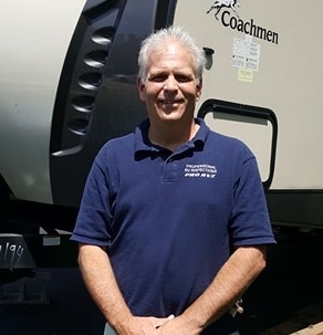 Master Certified RV Inspector Rob Wilhelm in front of his Coachmen travel trailer